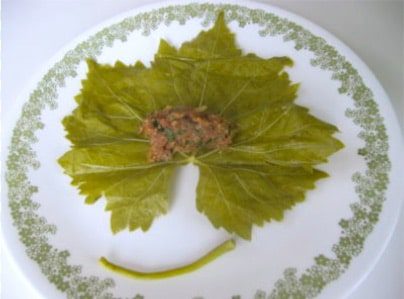 Putting filling on to grape leaves